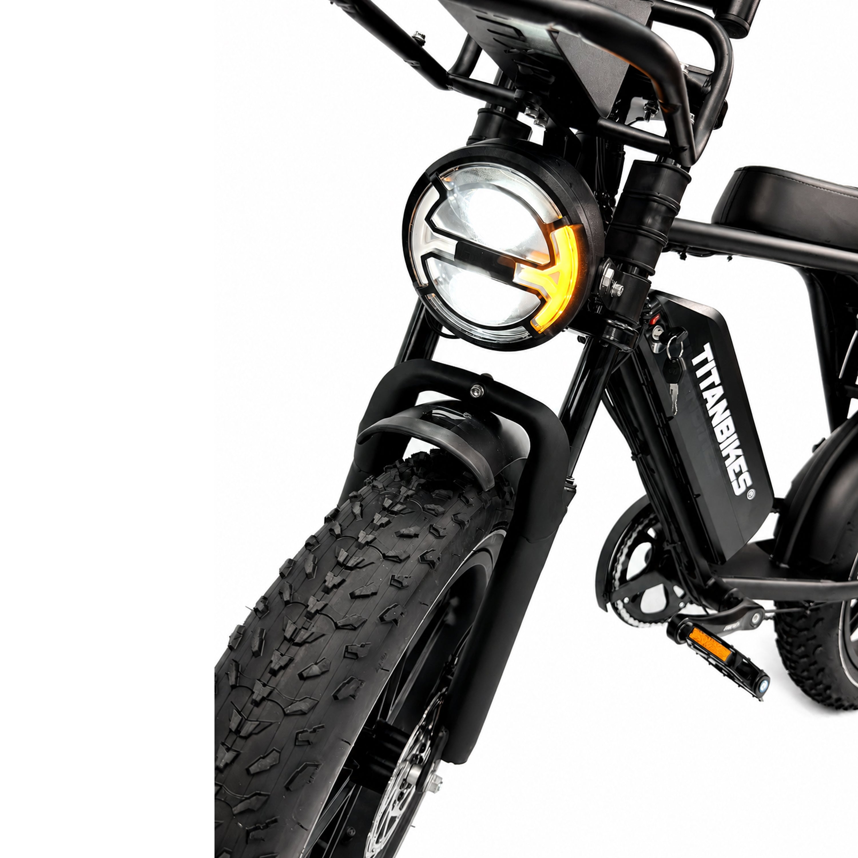 Close-up van het voorwiel, de koplamp en het accupakket met het opschrift TITANBIKES op een zwarte OUXI FATBIKE V8 (C80) – MODEL 2026 elektrische fatbike, gefotografeerd tegen een witte achtergrond, waarbij de robuuste hydraulische remmen en de kenmerkende eigenschappen van het nieuwste OUXI-ontwerp goed tot hun recht komen.