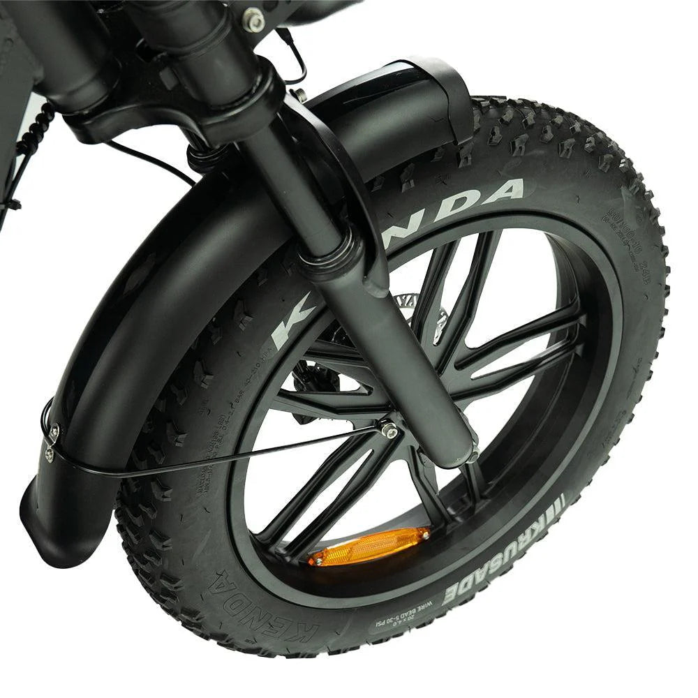 Close-up van het voorwiel van de OUXI FATBIKE OUXI V8 PRO (C80 PRO) – MODEL 2026, met een dikke Kenda-band met grove profielblokken, zwarte spaken en een spatbord. Aan één spaak van deze krachtige elektrische fatbike van OUXI is een oranje reflector bevestigd.