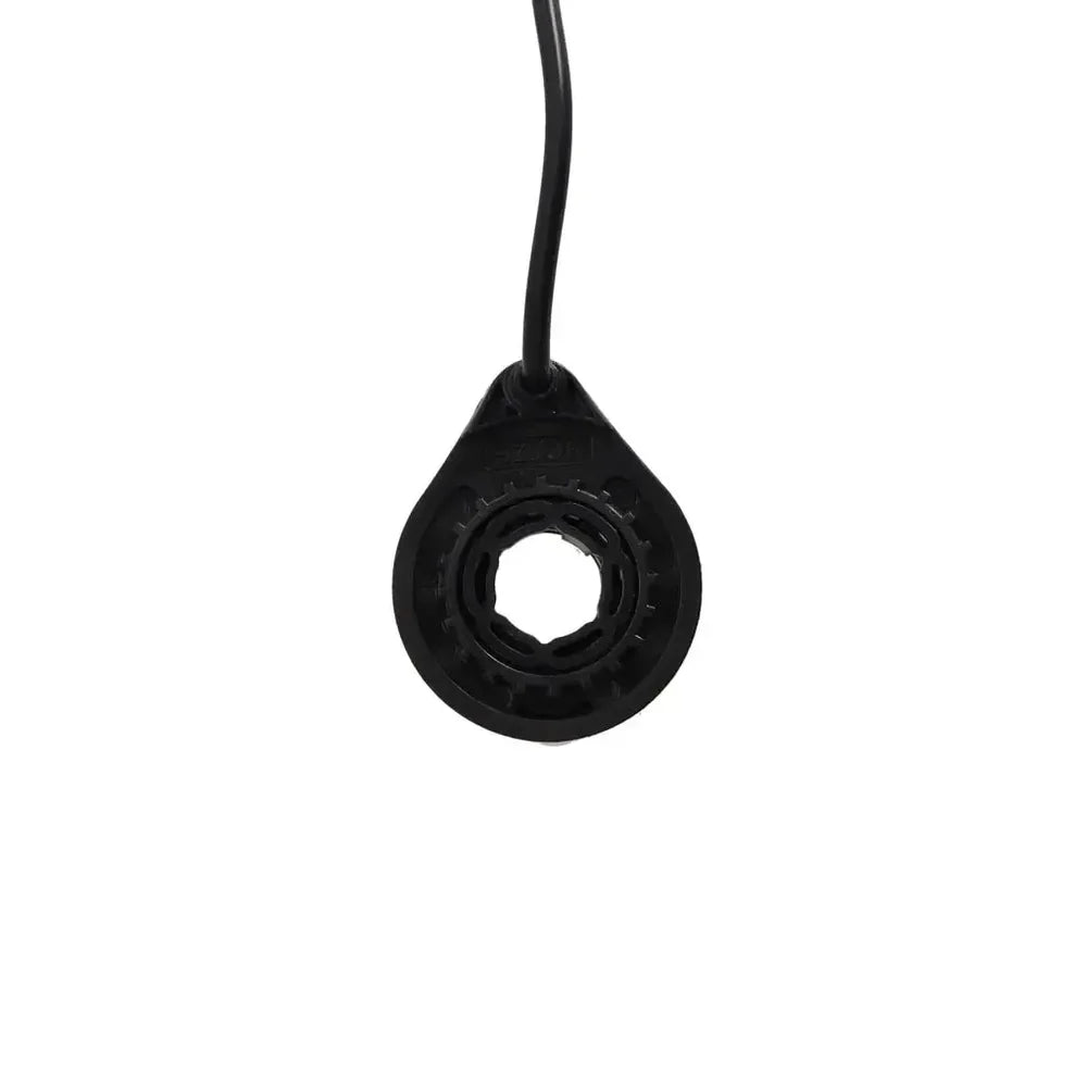 Zwarte, ronde QMWHEEL V20 (PRO) snelheidssensor met een opening in het midden en een vastgemaakte kabel, afgebeeld tegen een effen witte achtergrond. Deze QMWHEEL-snelheidssensor is ontworpen voor betrouwbare prestaties als originele snelheidssensor voor fatbikes of e-bikes en is bedoeld voor montage onder het zadel.