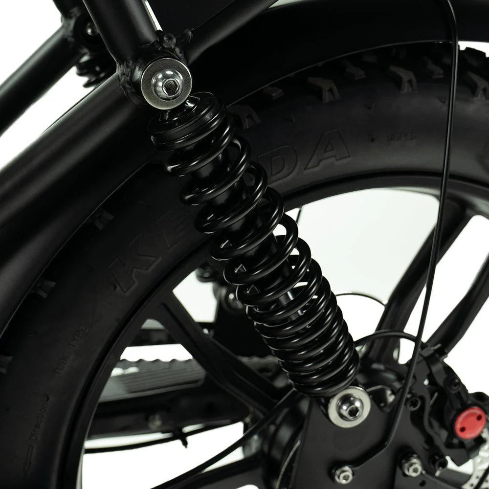 Close-up van een zwarte achterveringveer, een wiel en een band van de OUXI FATBIKE V8 PRO (C80 PRO) – MODEL 2026 e-bike, met zichtbare spaken en een deel van het hydraulische remsysteem, afgebeeld tegen een witte achtergrond.