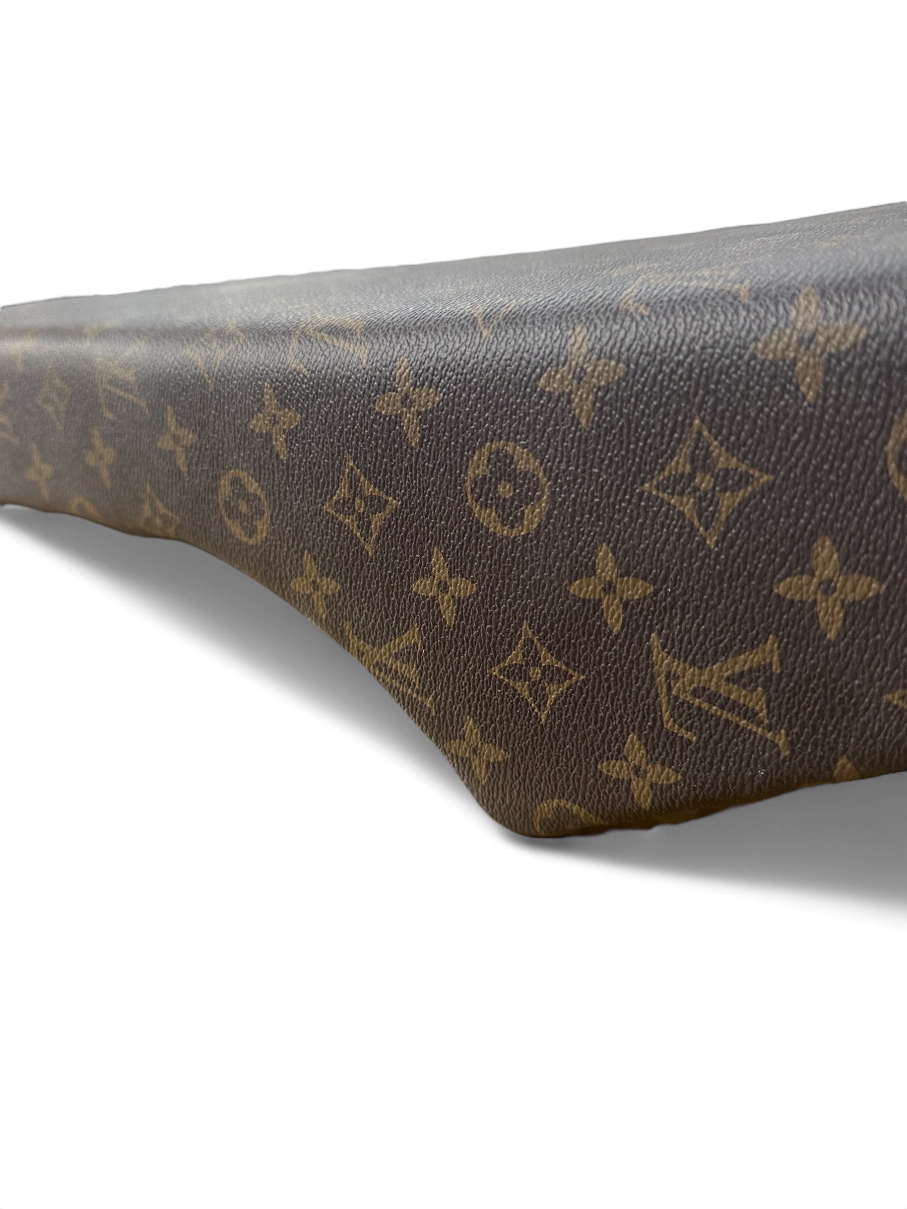 Een close-up van bruin leer met een goudkleurig Louis Vuitton-monogrampatroon, waarbij de textuur en de rondingen van het materiaal tegen een witte achtergrond goed tot hun recht komen — wat doet denken aan de luxueuze afwerking van een QMWHEEL of OUXI FATBIKE ZADEL CUSTOM V20 - V8 - H9 in diverse kleuren.