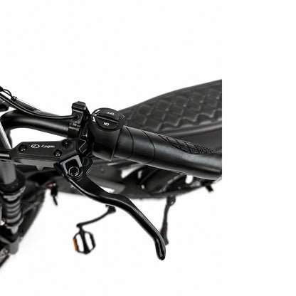 Close-up van het zwarte stuur van de OUXI FATBIKE V8 (C80) – MODEL 2026, met een bedieningsschakelaar met de aanduidingen M en NO, een handgreep met structuur, een hydraulische remhendel (hydraulische remmen), een deel van het gewatteerde zadel en pedalen – dit alles tegen een witte achtergrond.