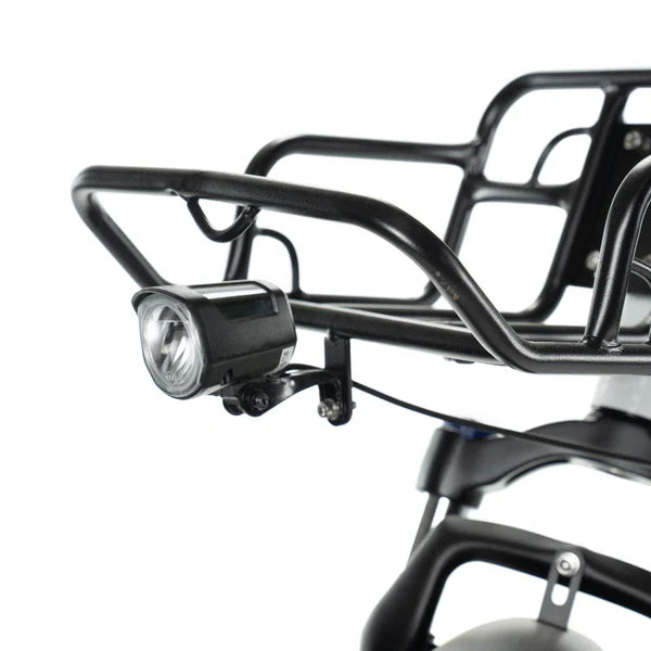 Close-up van een zwart metalen voorbagagedrager met een gemonteerde koplamp, bevestigd aan de vork en het wiel van een ENGWE L20 – FATBIKE — ideaal voor elektrische fatbikes of robuuste modellen van ENGWE.