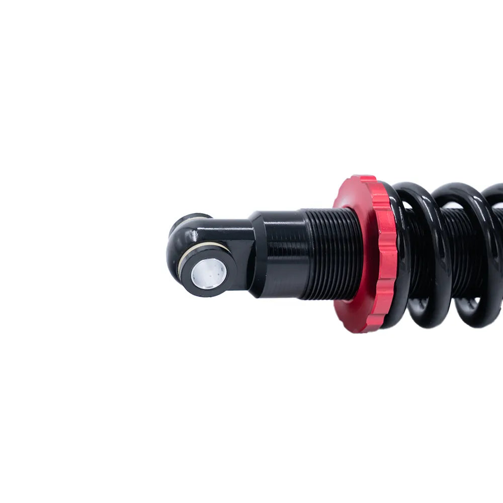Close-up van de QMWHEEL S20 (PRO) - VERING - ORIGINEEL, een zwarte schokdemper met spiraalveer en een rode instelring, geïsoleerd op een witte achtergrond. Deze originele vering van QMWHEEL is speciaal ontworpen voor de S20 Pro en is een ideaal vervangingsonderdeel voor fatbikes.
