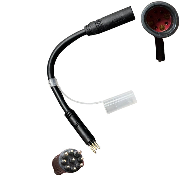 Een zwarte TitanBikes TUSSENKABEL MOTOR ROOD (vrouwtje) - ZWART (mannetje) adapterkabel voor elektrische fatbikes, voorzien van meerpolige connectoren: één met metalen pinnen en één met bijbehorende gaten. Aan de kabel is een doorzichtige plastic dop bevestigd, waardoor deze ideaal is voor aansluiting op de motorregelaar.