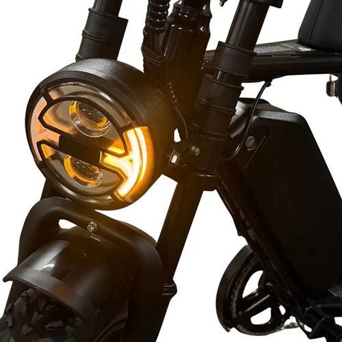 Close-up van de OUXI FATBIKE V8 PRO (C80 PRO) – De voorkant van het MODEL 2026, met een ronde koplamp met een verlichte oranje LED-ring, een robuuste voorband, stevige vorken en een deel van het frame – waarmee de opvallende kenmerken van deze krachtige elektrische fatbike met hydraulische remmen en een geïntegreerd alarmsysteem worden benadrukt.