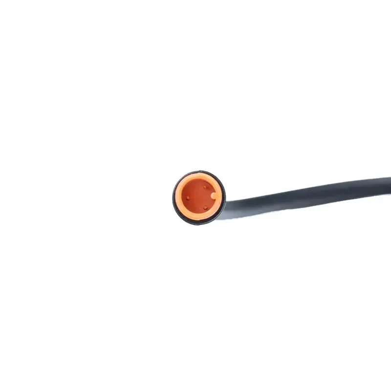 Close-up van het uiteinde van een zwarte kabel met een oranje, ronde 3-pins connector van het model OUXI - QMWHEEL - GAS HENDEL - ORIGINEEL, voorzien van twee kleine gaatjes, afgebeeld tegen een effen witte achtergrond.