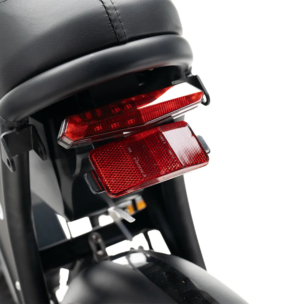 Close-up van het achterzadel, het achterlicht en de rode reflector van een motorfiets, waarbij de nadruk ligt op het zwarte zadel en het spatbord met hun uiterst gedetailleerde bevestigingsonderdelen en verlichtingscomponenten – vervaardigd met dezelfde precisie als de OUXI FATBIKE V8 (C80) MAX Dubbele Accu Model 2026 van OUXI, bekend om zijn robuuste ontwerp, hydraulische remmen en veiligheidsvoorzieningen.
