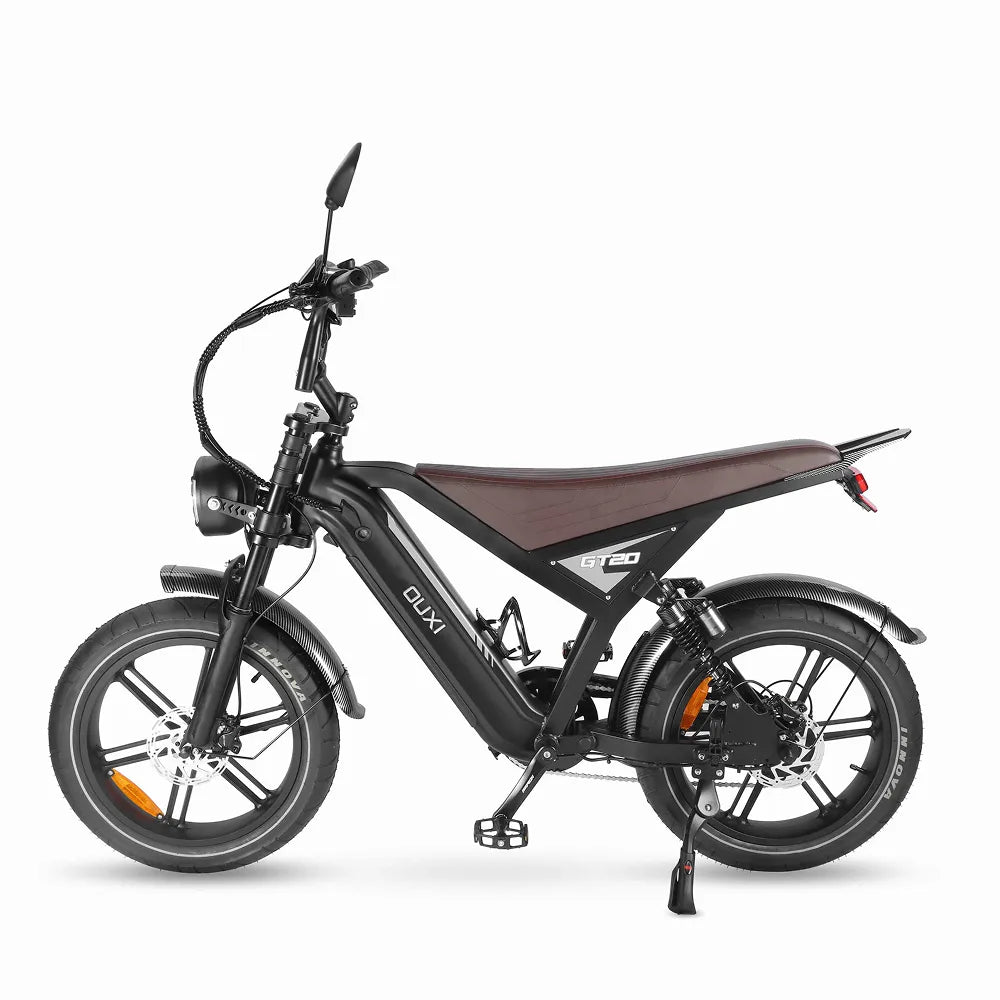 Zijaanzicht van een zwarte FATBIKE OUXI GT20 – MODEL 2026 van OUXI met een bruin zadel, voor- en achterspatborden, koplamp, achteruitkijkspiegels, dikke banden en hydraulische remmen. De fiets staat op een standaard tegen een witte achtergrond.