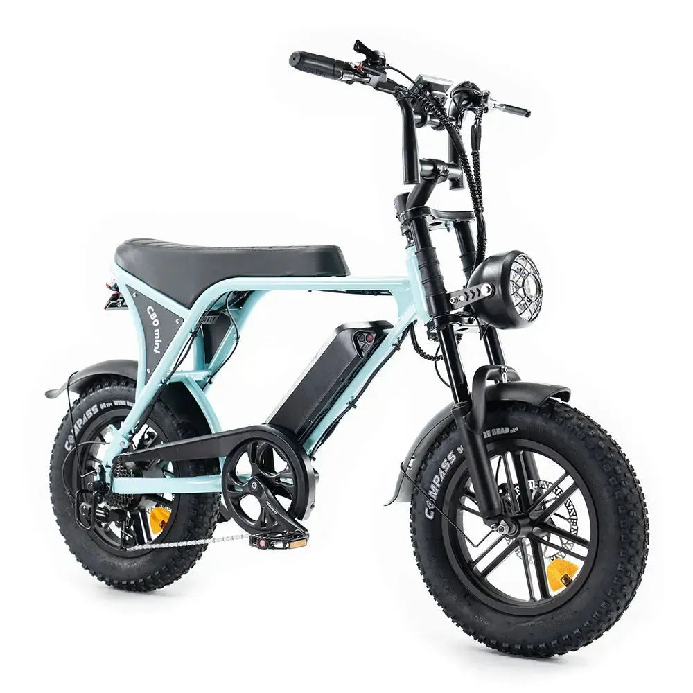 De OUXI FATBIKE OUXI C80 MINI in lichtblauw (MODEL 2026) is een compacte elektrische fatbike met dikke banden, een zwart zadel, pedalen, een koplamp en een zichtbare accu die op het frame is gemonteerd. Deze e-bike is uitgerust met hydraulische remmen, een alarm en een krachtige motor van 250 W voor soepele en efficiënte ritten. Afgebeeld tegen een witte achtergrond.