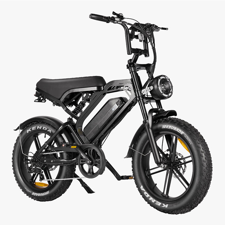 Maak kennis met de QMWHEEL FATBIKE V20 – MODEL 2025 - MECHANIC: een strakke zwarte elektrische fatbike met een compact frame, een geïntegreerde 48V 15Ah-accu, een lange zitbank, een ronde koplamp aan de voorkant en robuuste Kenda Krusade fatbanden op lichtmetalen velgen – allemaal gepresenteerd tegen een witte achtergrond.