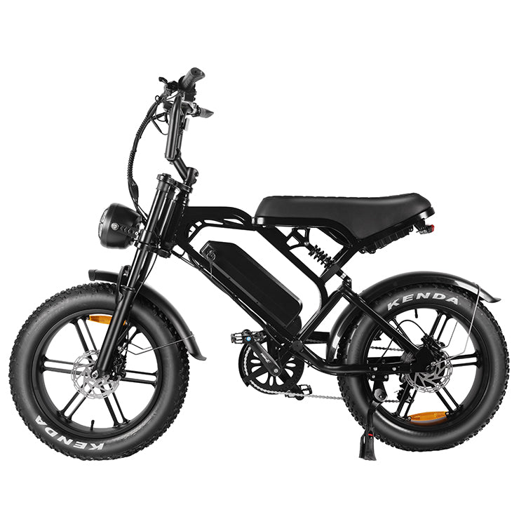 De QMWHEEL FATBIKE V20 – MODEL 2025 - MECHANIC is een zwarte elektrische fatbike met dikke Kenda-banden, een lage instap en een centraal geplaatste 48V 15Ah-accu. Deze fatbike is uitgerust met spatborden voor en achter, schijfremmen en een comfortabel zadel. Het Kenda-logo is duidelijk zichtbaar op de banden.